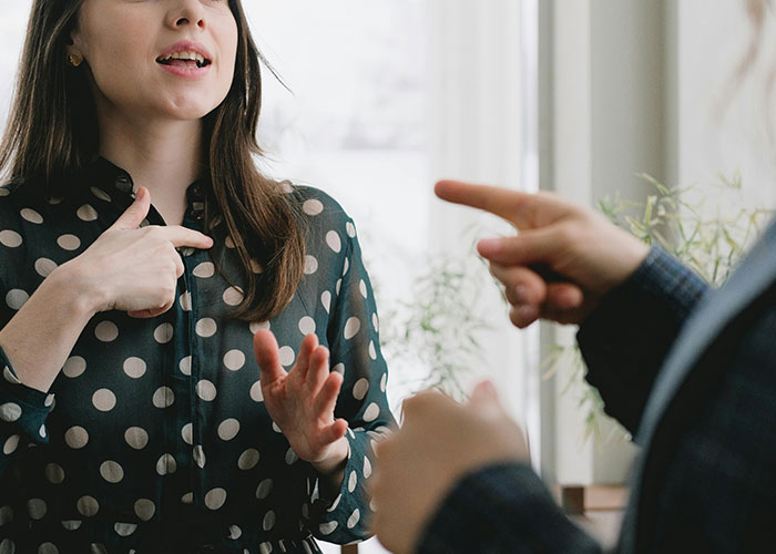 Teen and stepmom arguing indoors, tense moment capturing conflict over late mom&rsquo;s memory on wedding day.