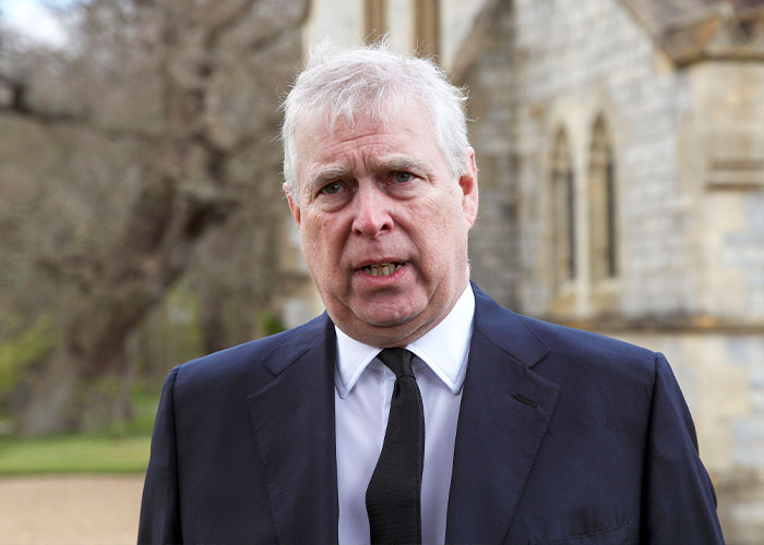 Ex-prince Andrew outdoors in a black suit and tie amid allegations linked to Epstein and exotic dancer claims.