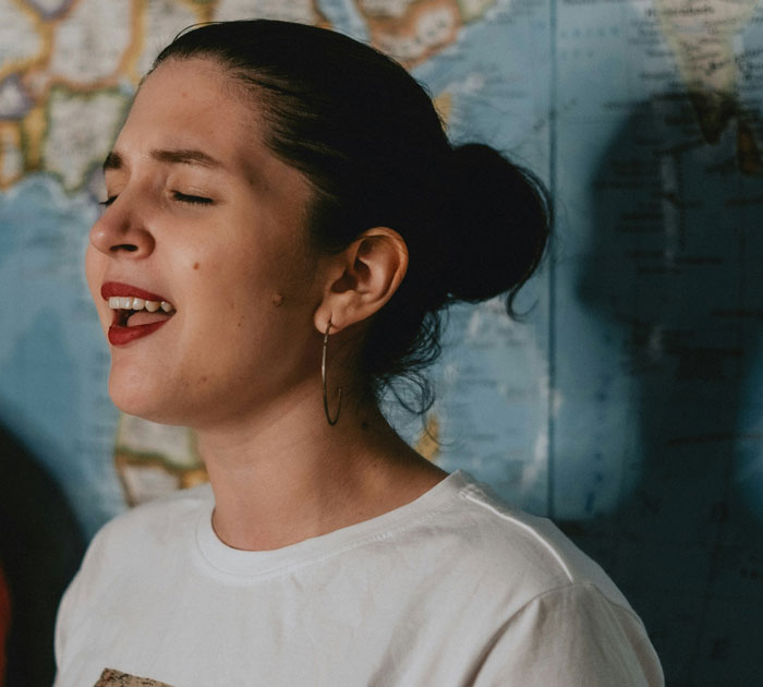 Young woman singing passionately with closed eyes, illustrating quick fixes that turned out to be genius solutions.