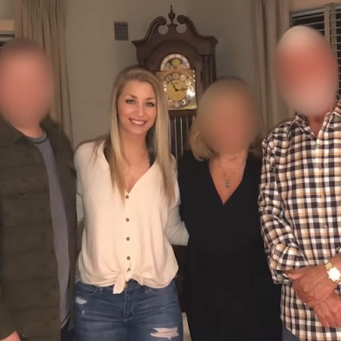 Young woman smiling indoors with blurred family members, related to judge firing back at teacher after student outcome.