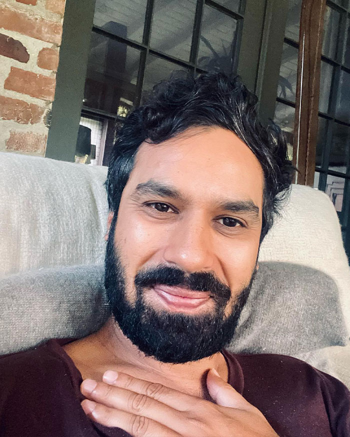 Kunal Nayyar from The Big Bang Theory sitting indoors, smiling with hand on chest, sharing GoFundMe revelation response.