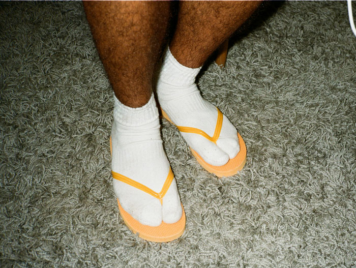 Healthcare workers wearing socks with sandals standing on a grey carpet, reflecting on things they will never do.