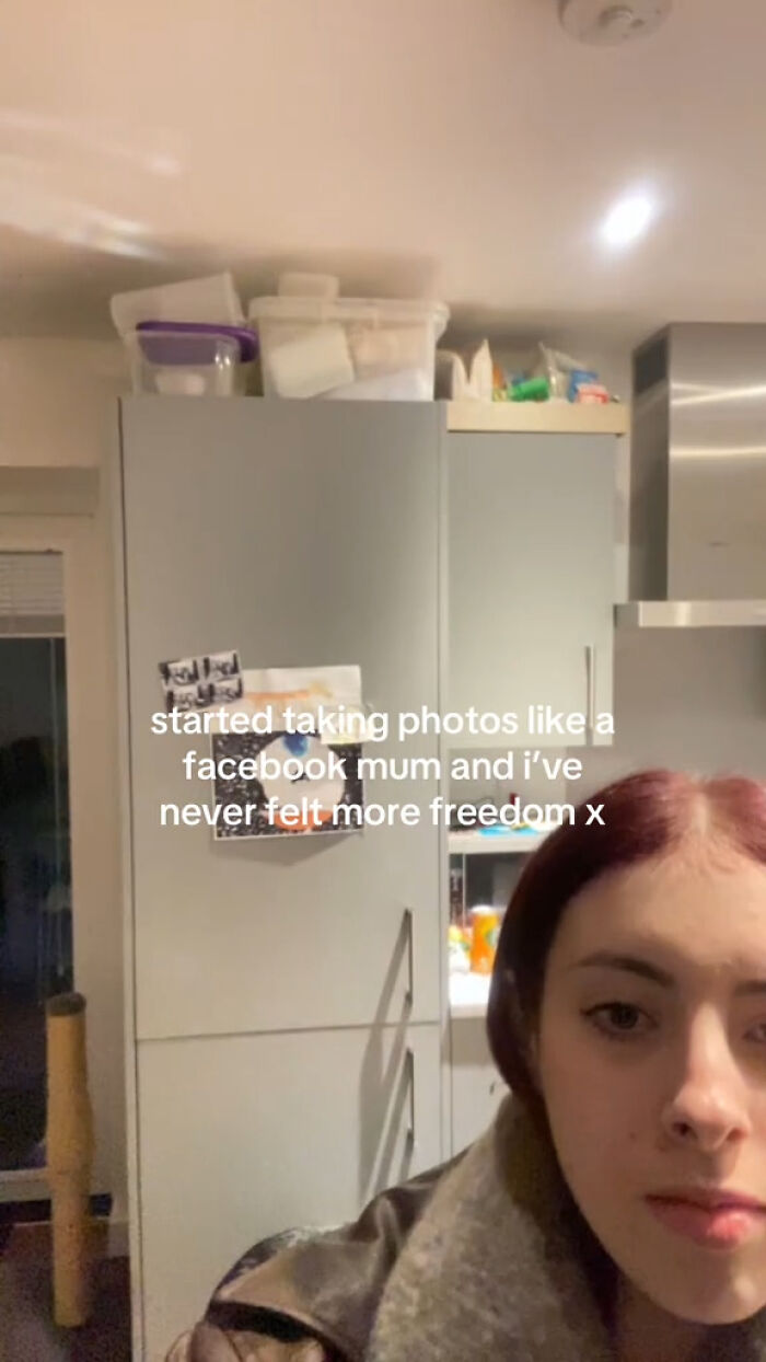 Woman taking a selfie in a kitchen, capturing the chaotic energy of a mom on social media with humorous expression.