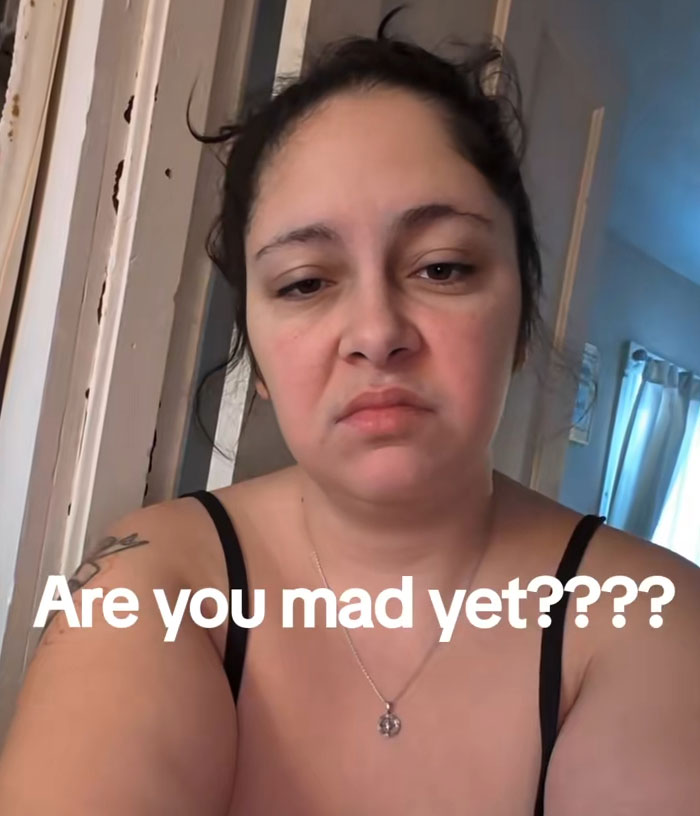 Woman with a frustrated expression in a casual setting highlighting emotions related to Frida Mom marketing controversy online.