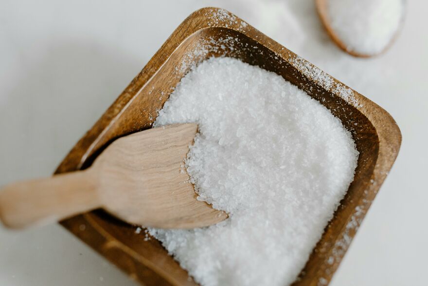 Wooden scoop in a wooden bowl filled with salt, demonstrating everyday items taking on new life with genius hacks.