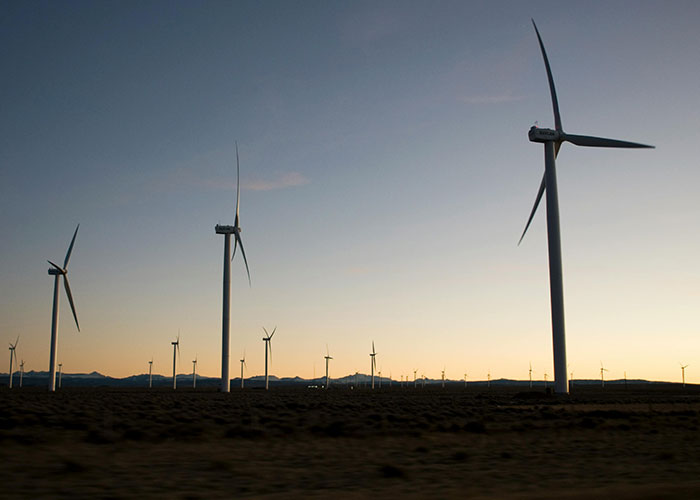Wind turbines at sunset showcasing sustainable energy, a smart feature countries have that just make sense to adopt.