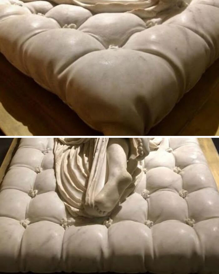 Marble sculpture depicting a detailed cushioned surface with a carved figure resting on a padded base, museum artifact.