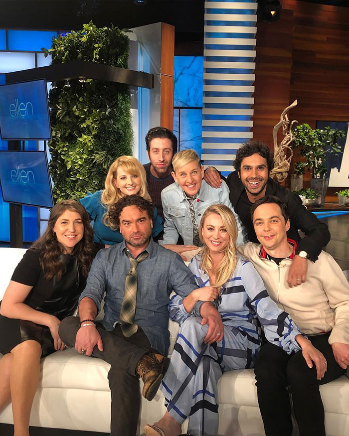 Cast of The Big Bang Theory sitting together on a couch, including Kunal Nayyar, during an Ellen Show interview.