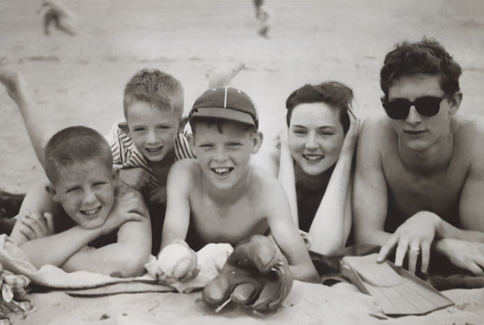 Black and white photo of five children lying on sand at the beach, related to harrowing 911 audio after tragic loss