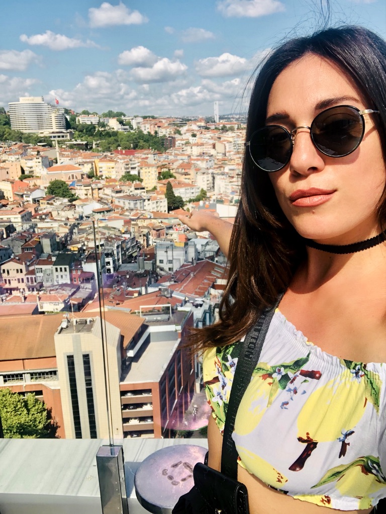 Woman wearing sunglasses overlooking a cityscape, representing living out of a suitcase and questioning successful life. Woman wearing sunglasses overlooking a cityscape, representing living out of a suitcase and questioning successful life.