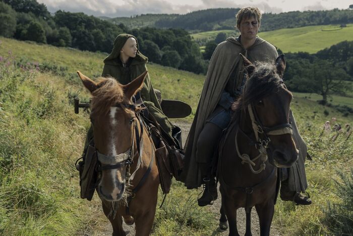 Two cloaked riders on horseback travel through a green countryside, evoking A Knight Of The Seven Kingdoms atmosphere. Two cloaked riders on horseback travel through a green countryside, evoking A Knight Of The Seven Kingdoms atmosphere.