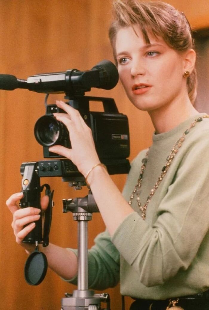 Young woman operating a vintage video camera, representing iconic actors who dominated Hollywood but then vanished.