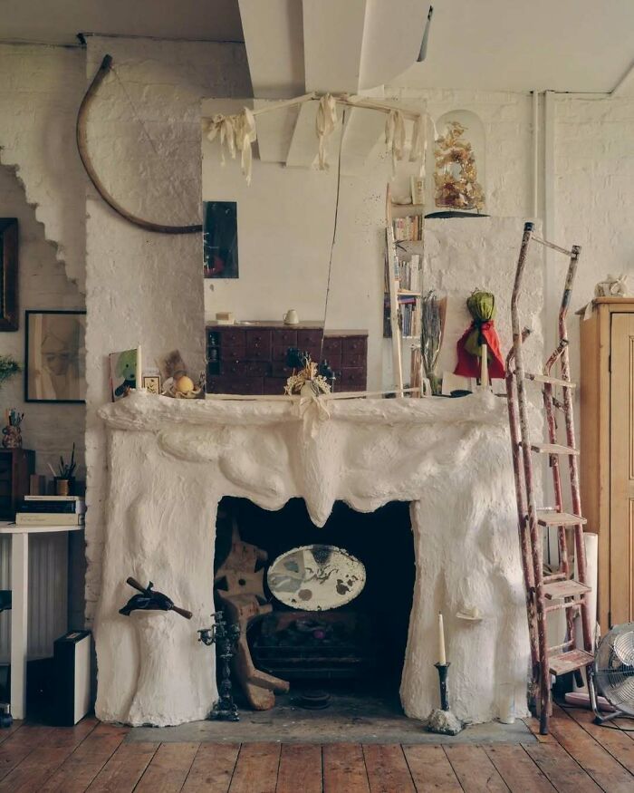 Cozy rustic interior with bold and beautiful fireplace design, vintage ladder, and eclectic decorative elements in living room.