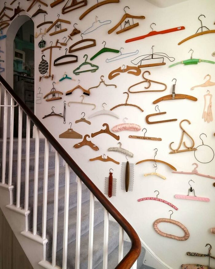 Staircase wall decorated with a bold and beautiful collection of vintage and colorful coat hangers for unique interiors.