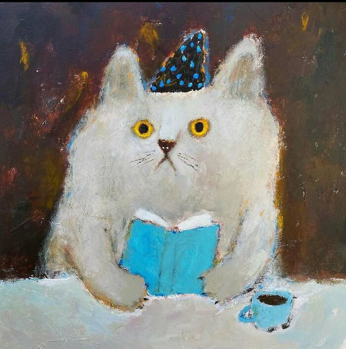 Whimsical painting of a white cat with yellow eyes wearing a party hat, reading a blue book with a cup nearby.