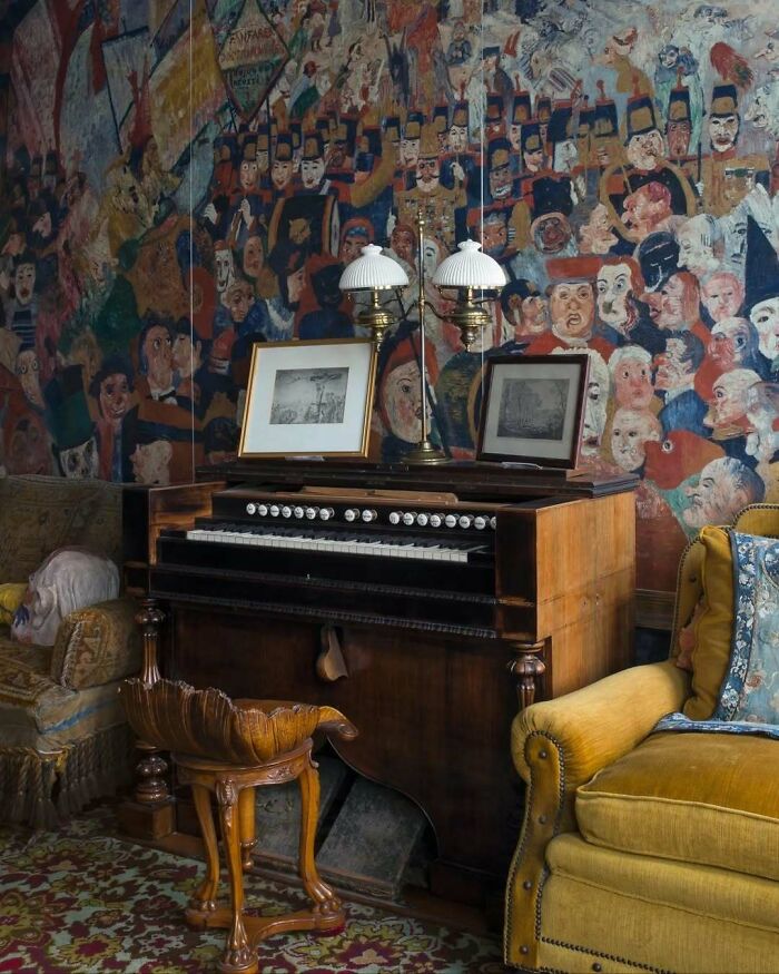 Eclectic interior featuring a vintage organ, bold mural wall art, and a mustard yellow armchair for beautiful stylish decor.