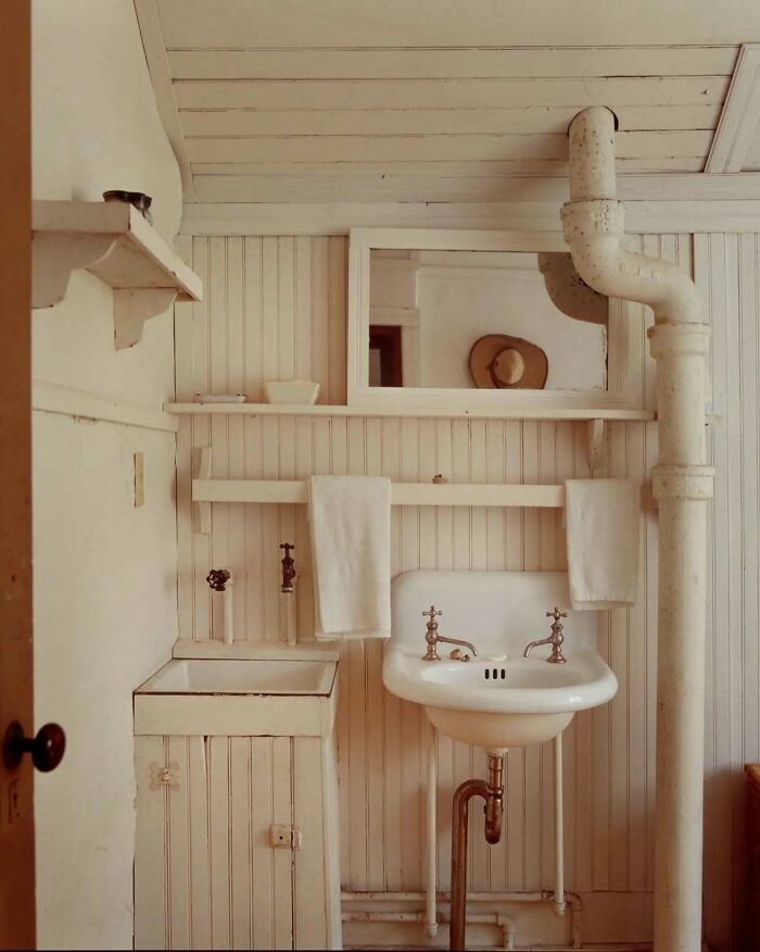 Vintage bathroom with bold and beautiful interiors featuring white wood paneling and classic fixtures.