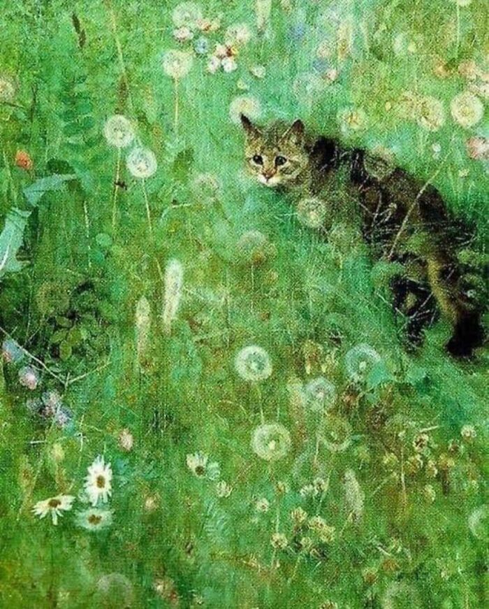 Tabby cat hidden in a lush green field with wildflowers, an example of paintings of cats as a favorite art subject.