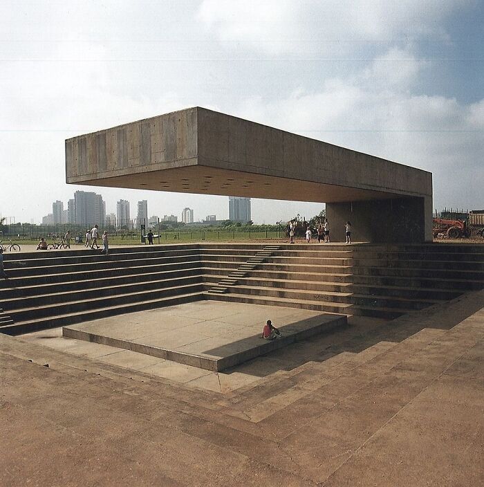 Modern architectural structure with floating concrete beam above stepped amphitheater, showcasing creativity in design and engineering.