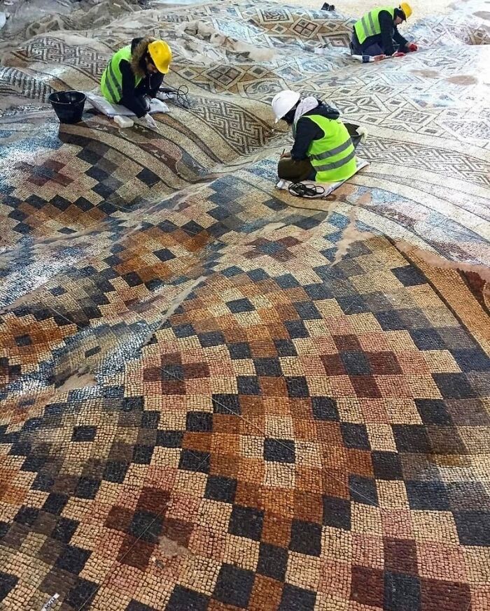 Workers restoring a detailed mosaic as part of amazing architectural structures showing humanity's creativity and craftsmanship.