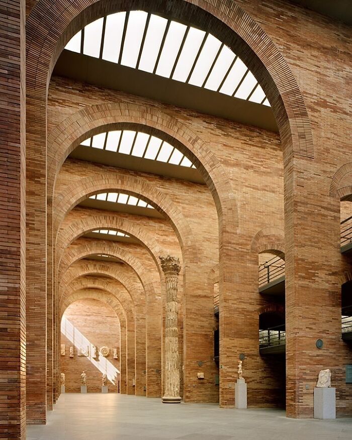 Spacious interior with towering brick arches and skylights showcasing beautiful and amazing architectural structures.