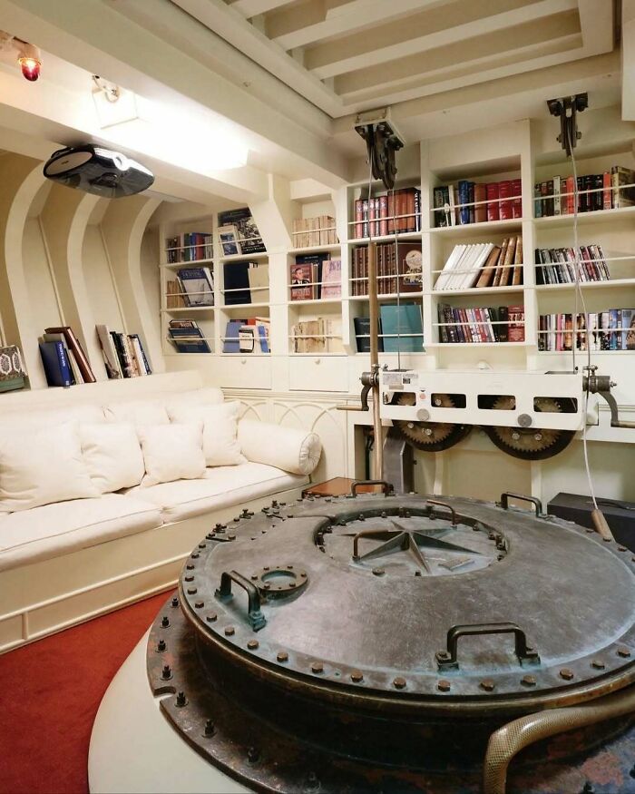 Bold and beautiful interiors featuring a cozy white sofa, built-in bookshelves, and unique industrial design elements.