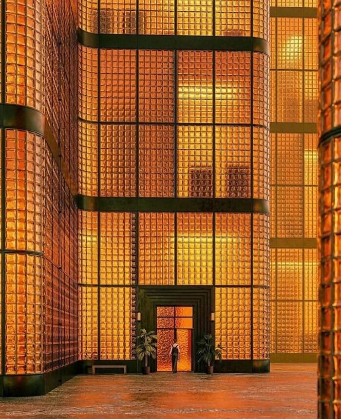 A person standing at the entrance of a glowing modern architectural structure showcasing creative design elements.