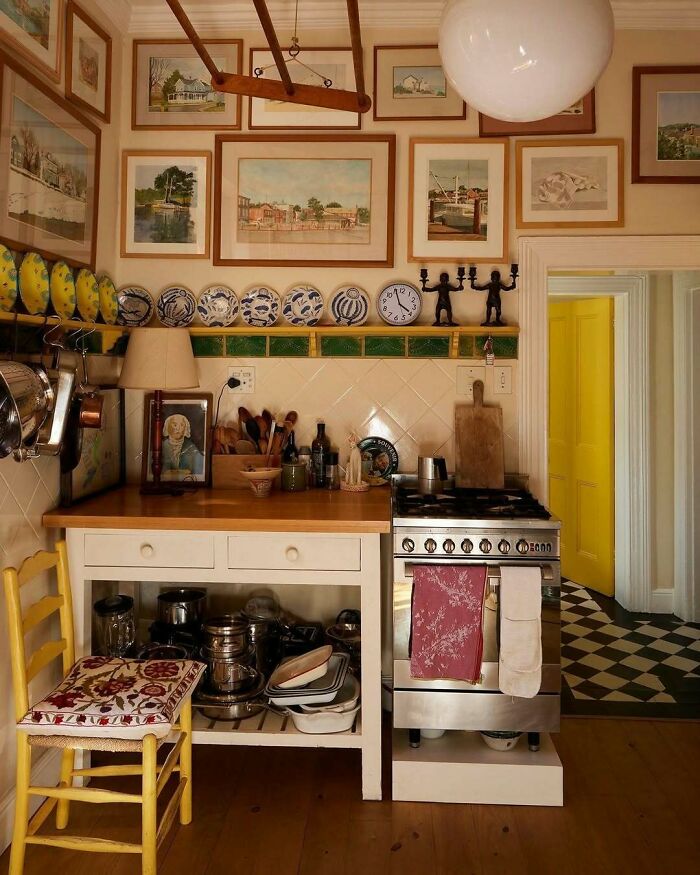 Cozy kitchen showcasing bold and beautiful interiors with vintage decor, framed art, and vibrant yellow door accents.