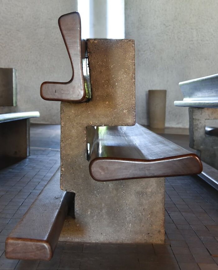 Concrete and wood bench with unique design in architectural structure highlighting creativity and craftsmanship.