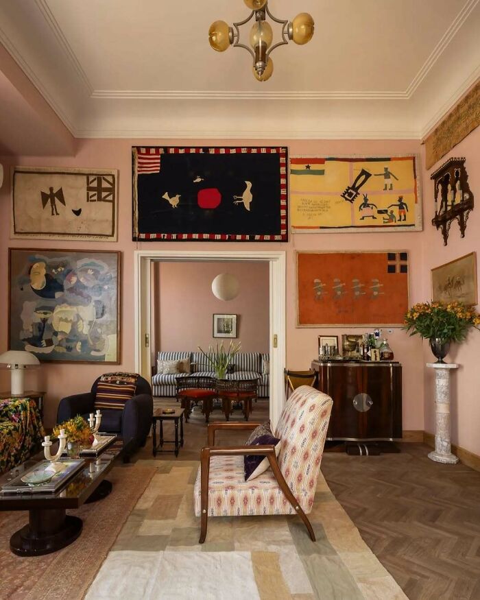 Elegant living room with bold and beautiful interiors featuring vintage furniture, patterned rugs, and colorful wall art.