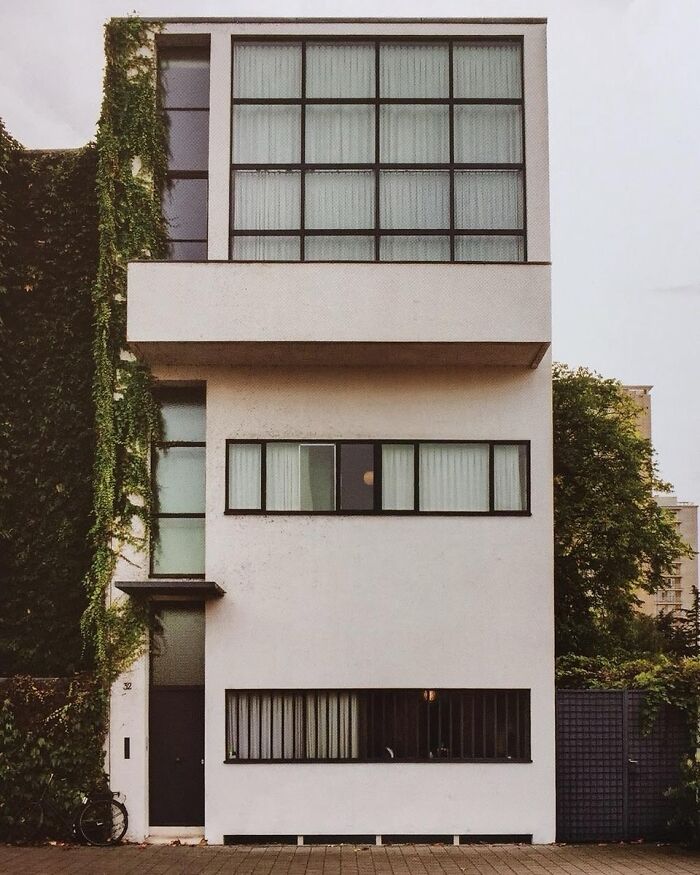 Minimalist modern architectural structure with large windows and vertical greenery on the side showcasing creativity.