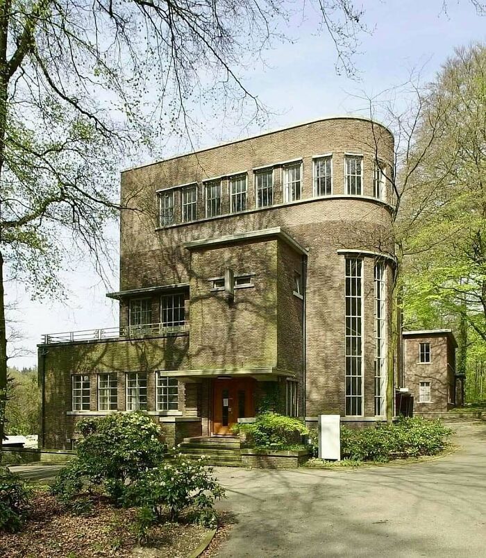 Modern brick architectural structure surrounded by trees showcasing unique design and creativity in architecture.