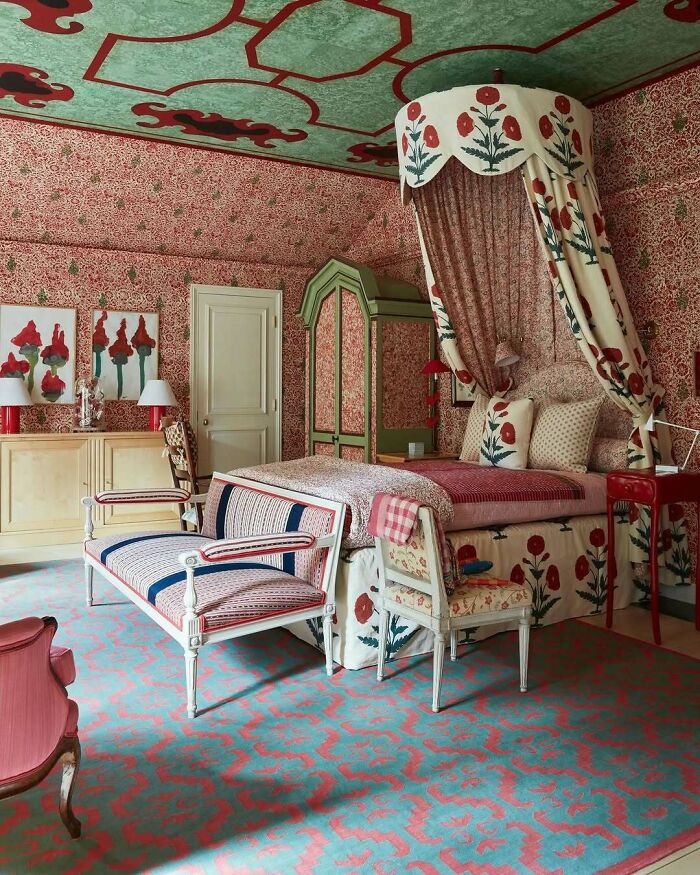 Bold and beautiful interiors featuring vibrant floral patterns and a unique canopy bed in a richly decorated bedroom.