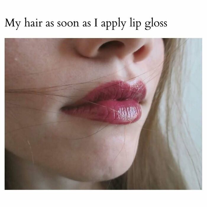 Close-up of lips with shiny lip gloss and strands of hair sticking to the face, showcasing a cute and wholesome moment.