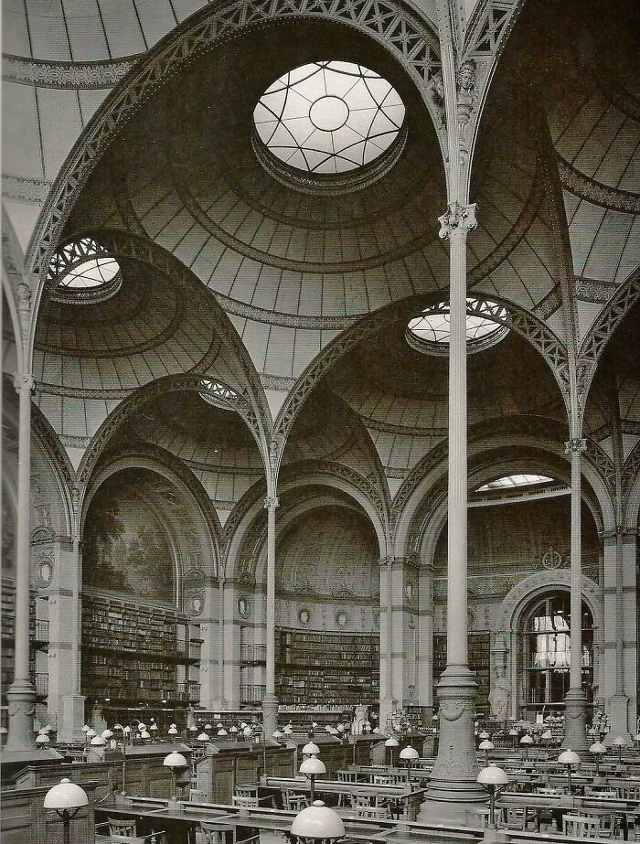 Interior of a grand architectural structure with ornate arches and a domed ceiling showcasing human creativity.