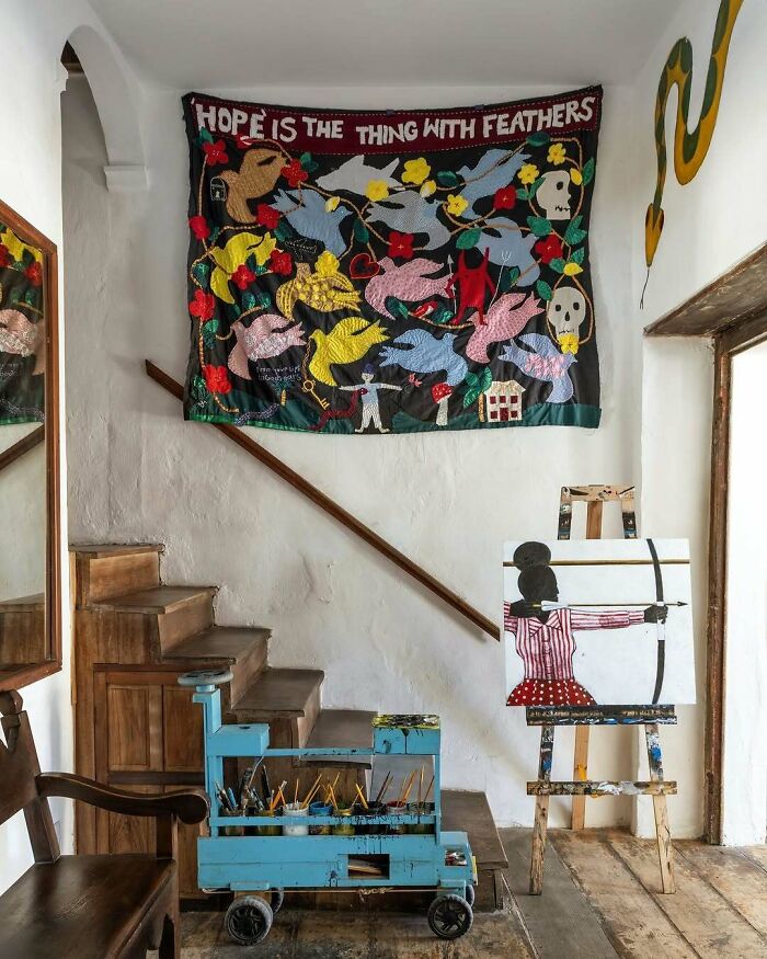 Bold and beautiful interiors featuring eclectic wall art, wooden stairs, and colorful artistic decor in a creative living space