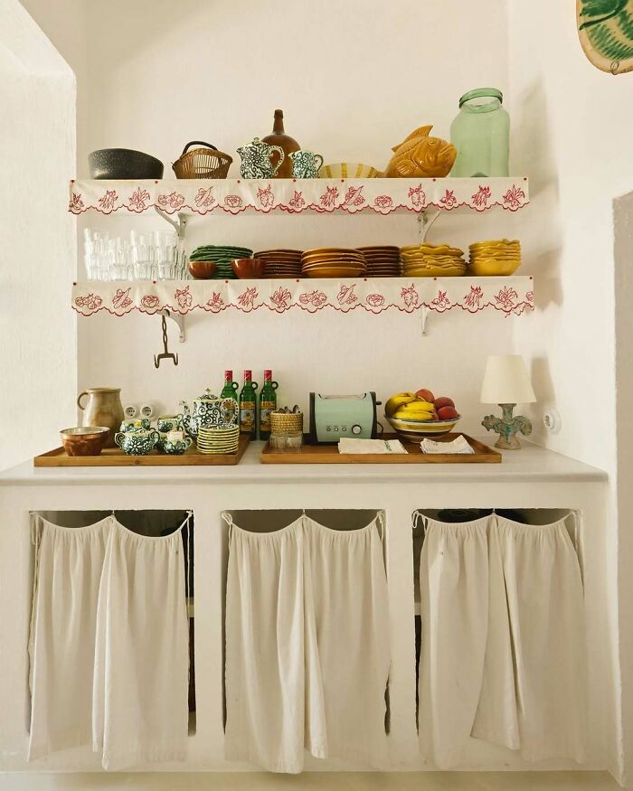 Cozy kitchen interior with shelves of colorful dishes and decorative vintage kitchenware in bold and beautiful interiors.