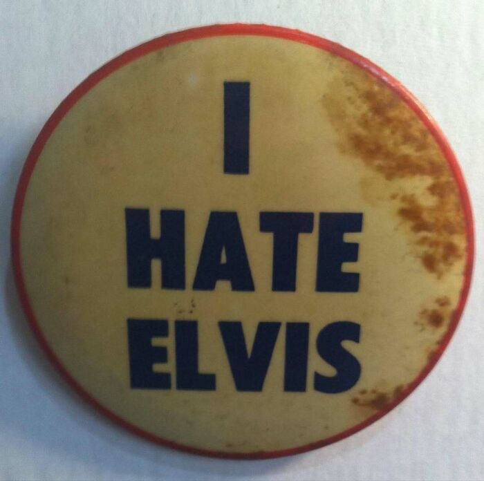 Round vintage pin with rust stains and bold text reading I Hate Elvis bizarrely funny image for mood boost.