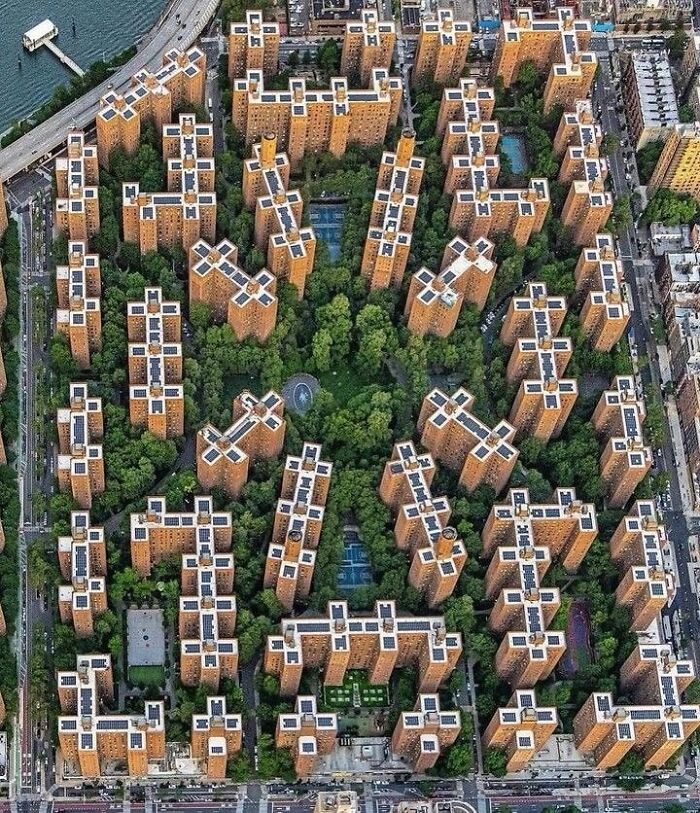 Aerial view of unique architectural structures surrounded by greenery, showcasing amazing creativity in urban design and architecture.
