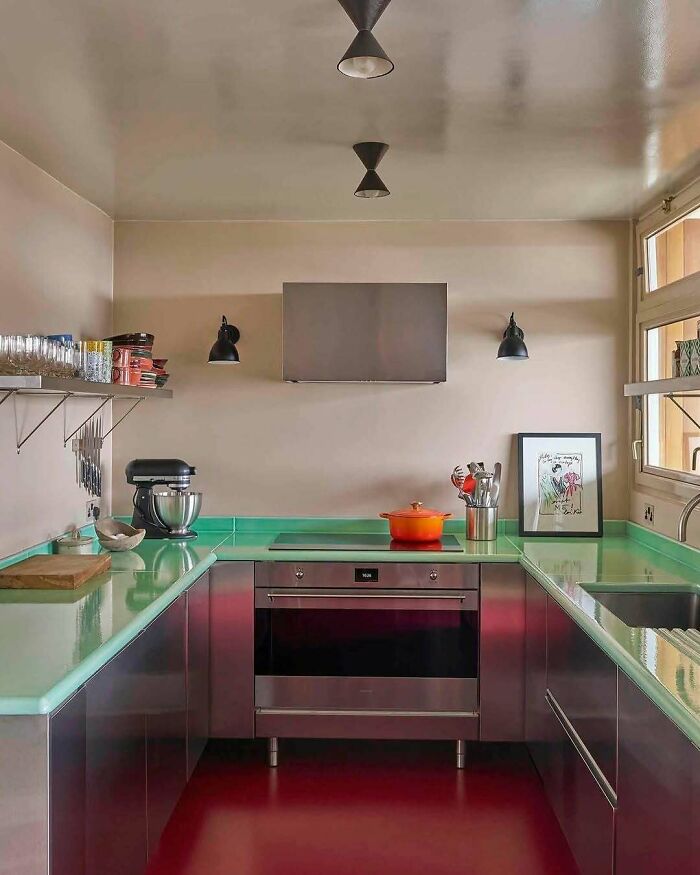 Modern kitchen with bold mint green countertops and sleek stainless steel cabinets in beautiful interiors design.