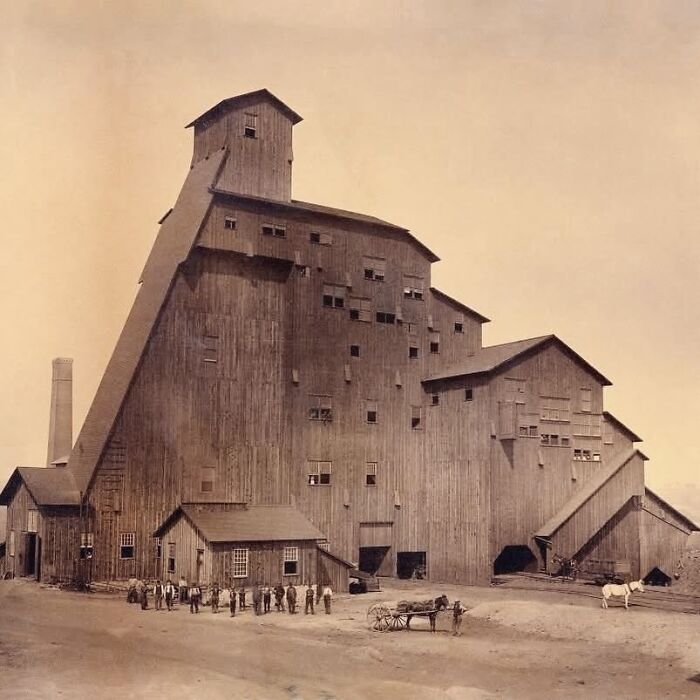 Large historic wooden architectural structure with multiple levels and small windows, showcasing creativity in architectural design.