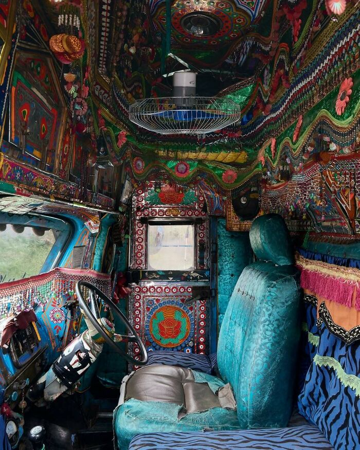 Vibrant and bold interiors of a vehicle cabin featuring colorful patterns, textured fabrics, and ornate decorative elements.