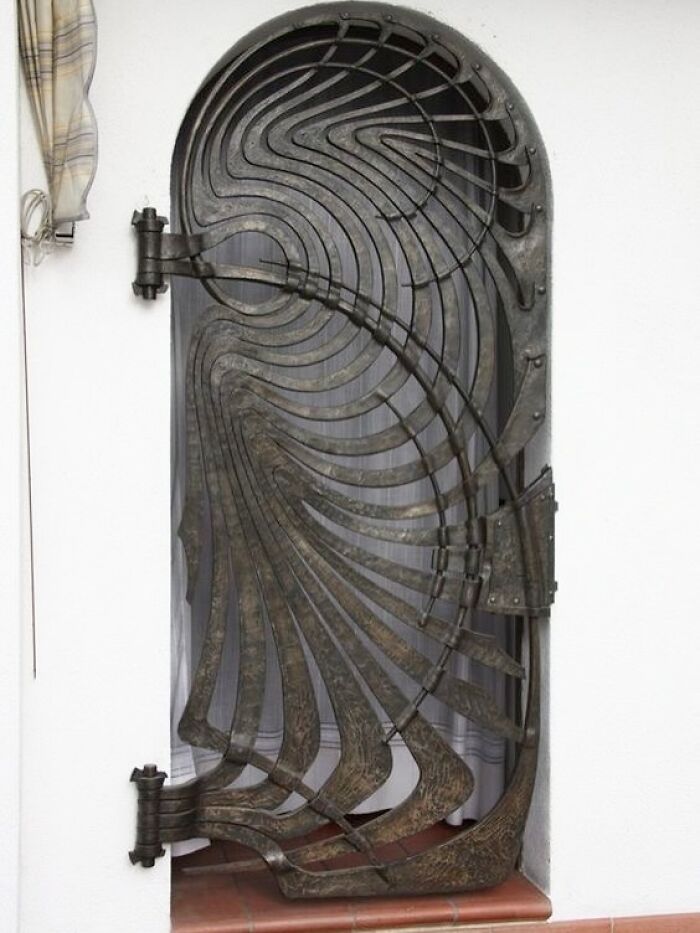 Ornate metal door with intricate swirling patterns showcasing beautiful and amazing architectural structures creativity.