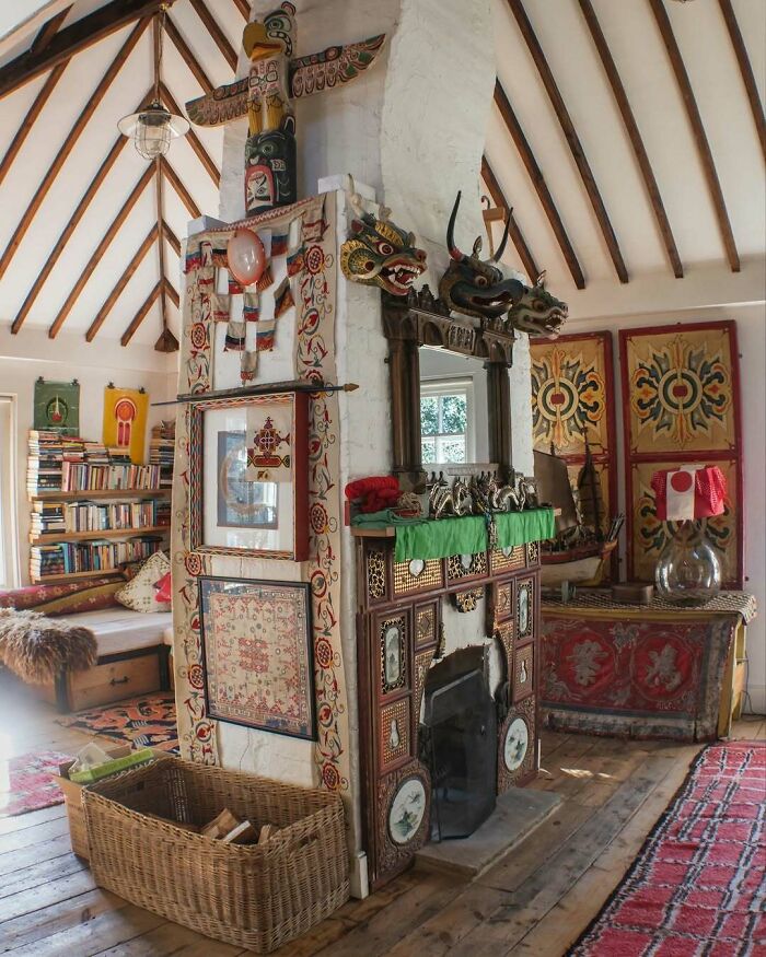 Bold and beautiful interior featuring a decorated fireplace, wooden beams, colorful textiles, and eclectic artwork.