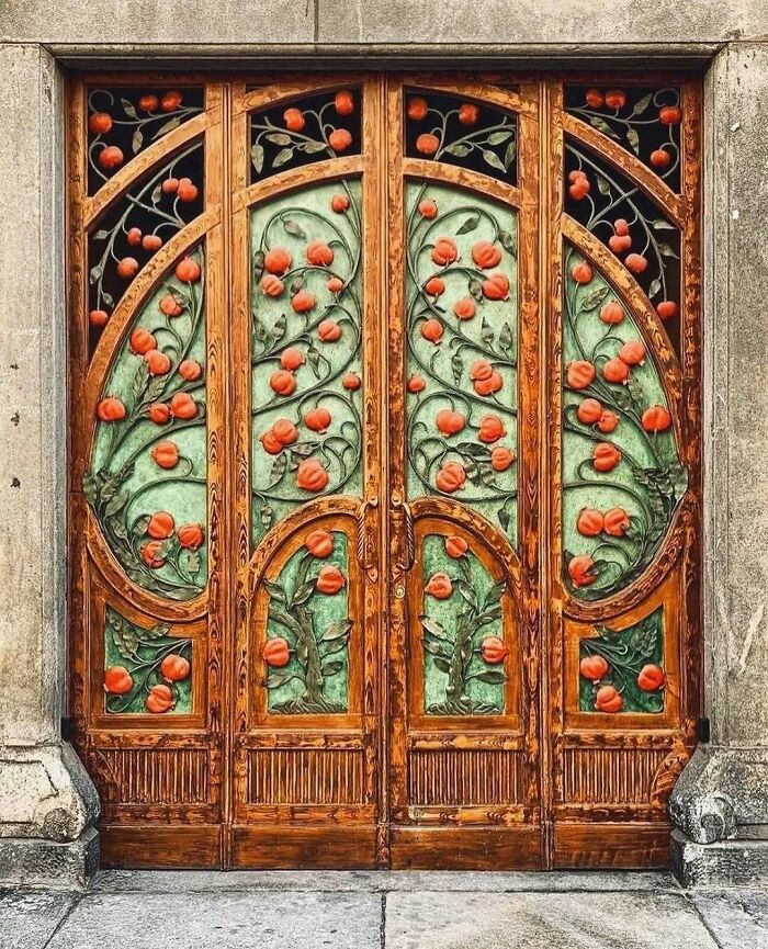 Ornate wooden door with floral designs and intricate metalwork showcasing beautiful and amazing architectural structures.