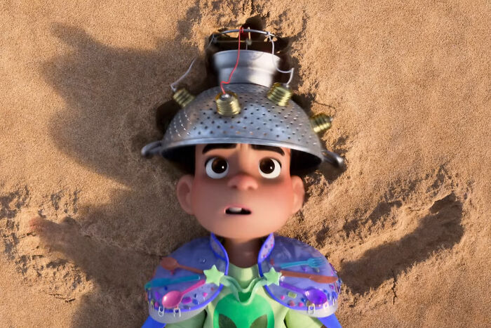 Animated character lying on sand wearing a makeshift metal helmet and colorful outfit in Oscar nominated movies 2026 scene.