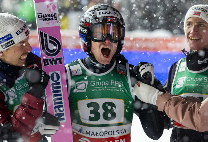 Three ski jumpers celebrating on the snowy slopes after a manhood scandal leads to rule changes in the Winter Olympics.