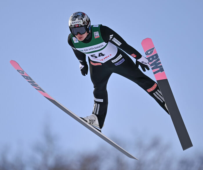 Male ski jumper in mid-air during Winter Olympics, highlighting manhood scandal and rule change in the event.
