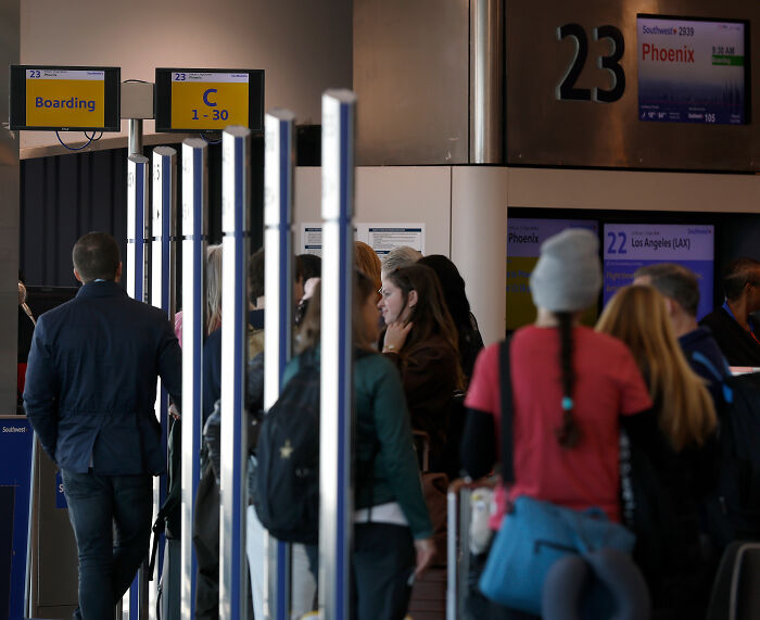 Passengers waiting in line at Southwest Airlines boarding gate, highlighting seating and family travel issues.