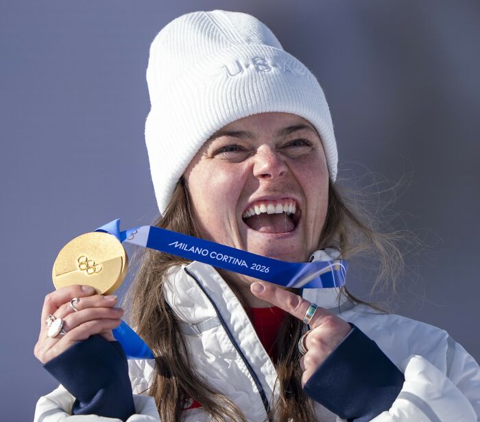 Olympian holding Milano Cortina 2026 medal, smiling, related to investigation after medals broke ordered from TEMU.